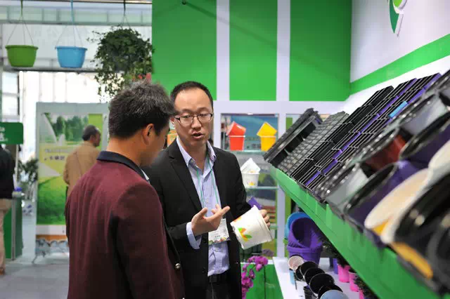 第17届中国国际花卉园艺展览会参展厂家向参观者讲解新产品